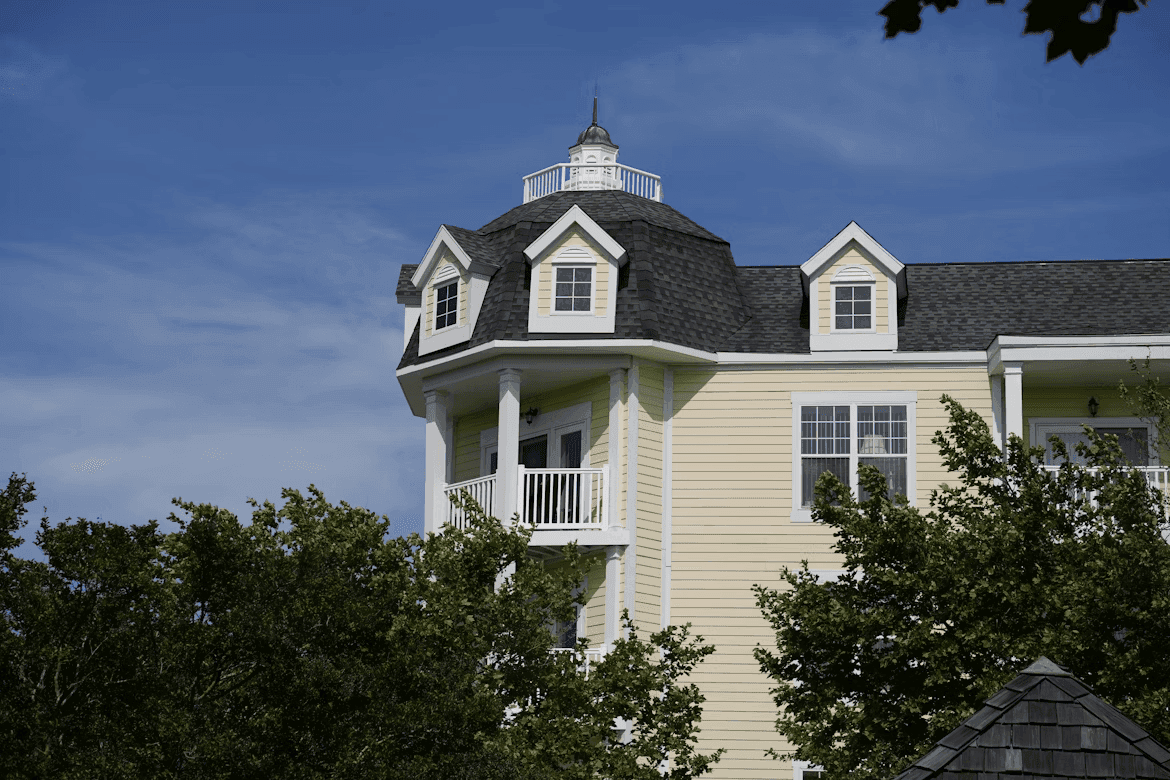 Traditional yellow apartment building featuring a prominent corner turret with a cupola